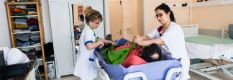 Aide soignantes posant un harnais lors du transfert d’un malade